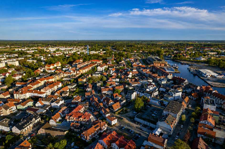 Biało-czerwona latarnia na końcu bałtyckiego molo o zachodzie słońca