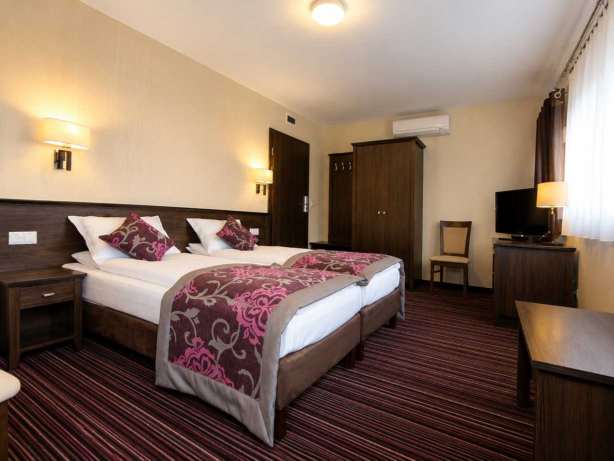 Jasny pokój hotelowy w stylu nadmorskim z miękką pościelą i ciepłym porannym światłem